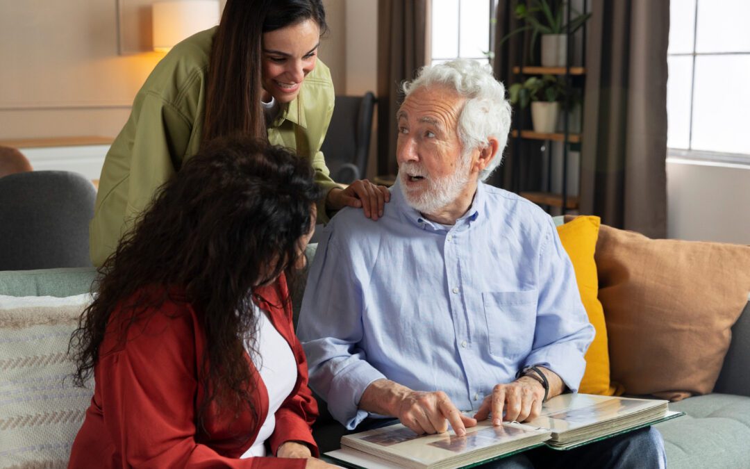 An old man sitting on a sofa, explaining something from a book to two young girls